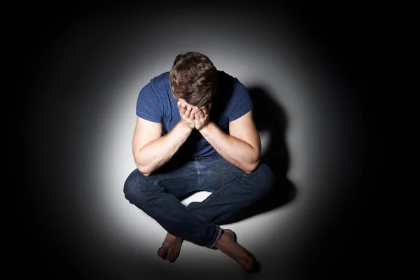 Ongelukkige jonge Man zitten In Pool van licht — Stockfoto