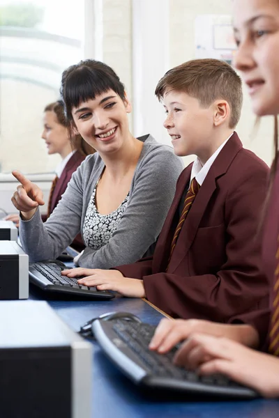 Ученик начальной школы в компьютерном классе с учителем — стоковое фото