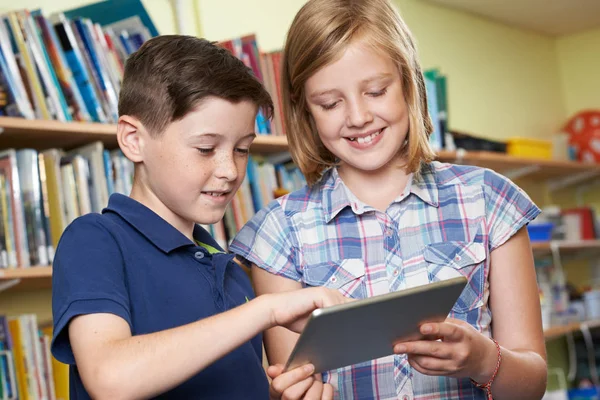 Воспитанники с помощью цифрового планшета в школьной библиотеке — стоковое фото