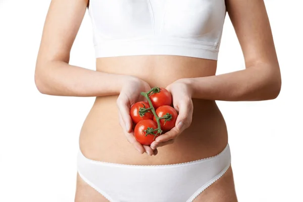 Gros plan de femme en sous-vêtements tenant des tomates — Photo