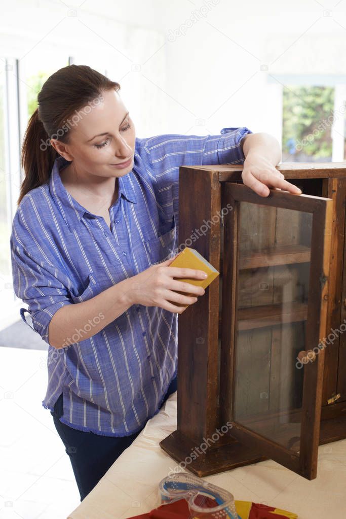 Woman Upcycling Wooden Cabinet At Home