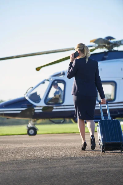 Вид сзади на предпринимательницу, идущую к вертолету, в то время как Таль — стоковое фото