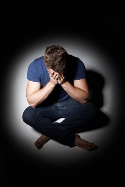 Işık havuzda oturan mutsuz genç adam