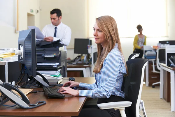 在繁忙的办公室在计算机工作的女实业家 — 图库照片