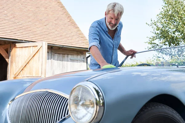 Mature Man Polishing Restored Classic Sports Car Outdoors Home Stock Picture