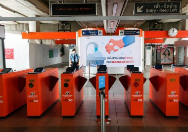Bangkok, Tayland 25 Mart 2020. BTS istasyonundaki güvenlik görevlisi Covid-19 'dan korunmak için yüz maskesi takıyor. Demiryolu departmanı tüm demiryolu yolcularının yüz maskesi takmasını ve aralarında yeterli boşluk bırakmasını şart koşuyor.