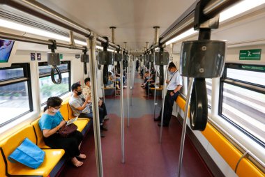 Bangkok, Tayland 25 Mart 2020. BTS trenindeki yolcular kendilerini Covid-19 'dan korumak için maske takarlar. Demiryolu departmanı tüm demiryolu yolcularının yüz maskesi takmasını ve yolculuk sırasında birbirleri arasında yeterli alan bırakmasını şart koşuyor.