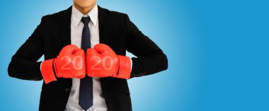 Siyah takım elbiseli, kırmızı boks eldiveni giyen, birbirine yumruk atan bir işadamı ve 2020 metni, açık bir çalışma amacı ile çalışıyor. Dikkatli ve dürüst planlama ve güvenilirlik. Başarı kavramı