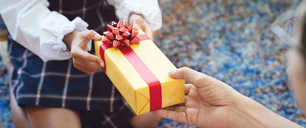 Aile için hediye olarak kırmızı kurdeleli sarı hediye kutusuyla kapanış. Mutlu yıllar ya da doğum günleri için iyi arkadaşlıklar yerine bir semboldür.