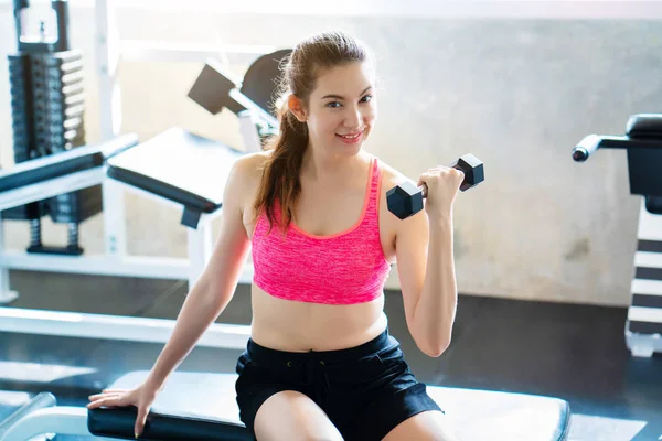 Spor salonunda ya da spor salonunda ağırlık kaldıran Asyalı kadınlar. Egzersiz sağlıklı bir vücuda ve güzel kaslara sahip olmaya yardımcı olur. Ve hastalık olmadan. Sağlık ve spor yapma kavramı