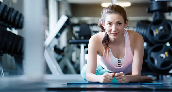 Asyalı kadınların mutlu gülümsemeleri. Spor salonunda spor kıyafetleri ve spor aletleri giyiyordu. Egzersiz sağlıklı bir vücuda, iyi forma ve kasları gevşetmeye yardımcı olur. Sağlık hizmetleri kavramları