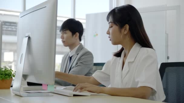 和同事一起坐在现代办公室里的亚洲商人女人用电脑查看市场信息 战略规划使用智能手机与客户交谈 概念业务合并 — 图库视频影像