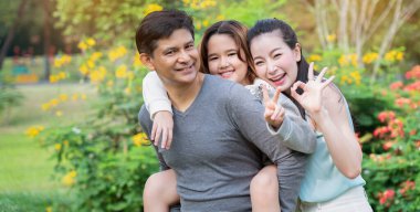 Asyalı aileler piknik yapmaktan mutlu olurlar. Parkta ebeveynlerin ve kızların faaliyetlerini yaparlar. Uzun yaz tatillerinde doğa hakkında iyi havayla bilgi edinin. Konsept Sağlık Sigortası COVID-19