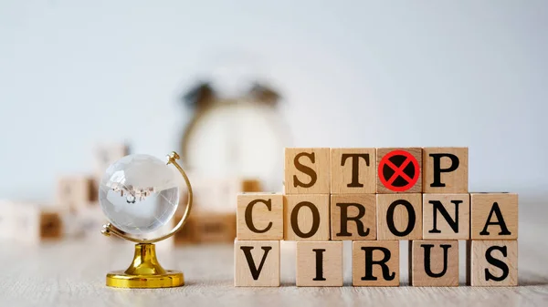 Coronavirus kavramı (COVID-19). Corona virüsünün dünya çapında yayılmasını engelle ya da durdur. Yayılan insandan insana güvenliğiniz için evinizde ve sosyal mesafenizde kalın. Tahtadaki harfler.