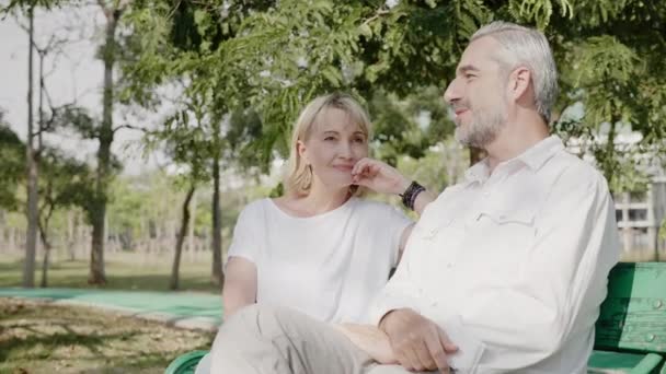 코카서스 부부는 여름에 정원에 앉아서 행복하게 이야기하는 남녀들 활동은 은퇴하여 — 비디오