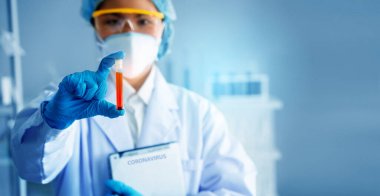 Coronavirus tedavisi ilacını ve laboratuvarda ya da hastanede yapılan araştırmaları aramak için kırmızı kimyasallar ya da mikroplar içeren bilimsel cam şişeyi tutan bilim adamlarının ellerine odaklanın. Kavram Koronavirüsü Durdur