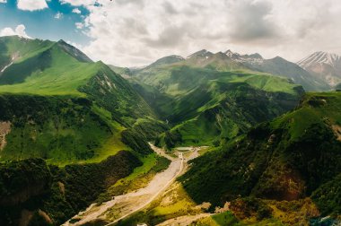 Dağ yeşil tepeler, yol kavşağı, gölün üzerindeki parlak güneş ışığı. Gürcistan 'ın güzel manzarası