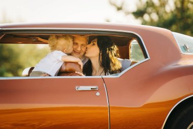 Buick Riviera 'nın retro tarzı. Benzersiz bir araba. Anne ve oğlu retro araba vitrininde babasını öpüyor.