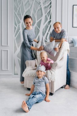 Mutlu bir aile evde kalır ve çocuklar için taç giyer. Koronavirüs değil. Evde kalmak için oyun, yaratıcılık ve gelişim kavramı.