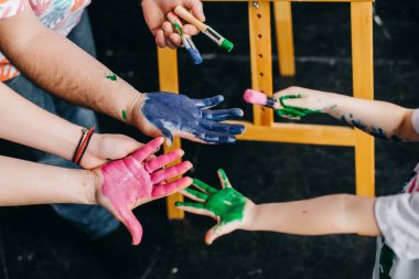 Yukarıdan bak. Ellerine renkli boya bulaşmış. Tüm aileyle çiz..