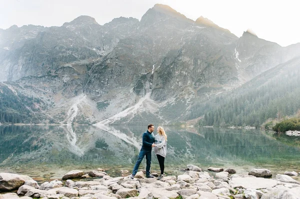 Lovely couple travelling together in the mountains, walking around the lake Morskie oko in Tatry.