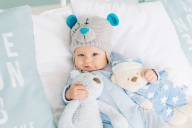 Küçük çocuk oyuncak ayıları sever. Oyuncak şapkalı bebek. Teddy gibi tatlı bir çocuk Oyuncakları olan sevgili