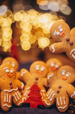 Noel ağacının yanındaki ormanda yeni yılı kutlayan zencefilli kurabiye şeklinde birçok Noel kurabiyesi.