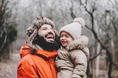 Yakışıklı genç baba ve tatlı kızı kışın dışarıda eğleniyorlar. Mutlu aile birlikte vakit geçiriyor. Aile kavramı.