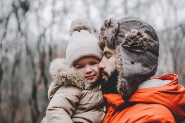 Yakışıklı genç baba ve tatlı kızı kışın dışarıda eğleniyorlar. Mutlu aile birlikte vakit geçiriyor. Aile kavramı.