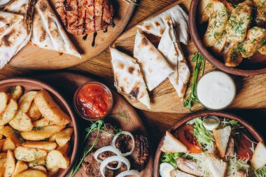 Büyük ve cömertçe nefis yemek masalarıyla kaplı ve üzerinde Ukrayna mutfağının çeşitli yemekleri var: barbekü, kızarmış patates, salata, sos, peynirli pita ekmeği.