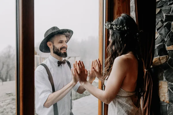 スタイリッシュな結婚式のカップルの肖像画 帽子の若い髭の男と髪型に編組花輪を身に着けているエレガントなガウンでブルネットの花嫁 — ストック写真