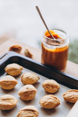 Pembe jöleli kalp şeklindeki kurabiyeler ve yazıtlar: Yazı arkaplanda yer alan bir Kraft kağıdına yerleştirilmiş aşk