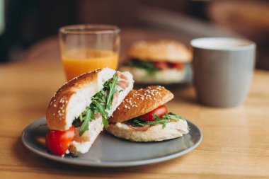 Büyük ve ağız sulandıran bir sandviç. Kahve masasının üzerinde sulu bir dolma var. Hazır kafede iki kişilik kahvaltı.