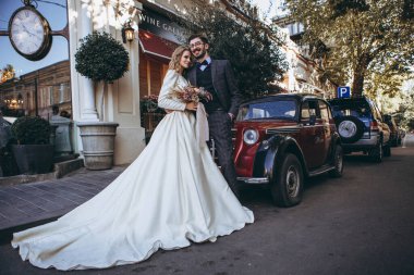 01.06.2019 Tiflis, Gürcistan usulü düğün: Gürcistan stili bıyıklı adam ve güzel elbiseli çekici sarışın gelin eski şehir sokaklarında fotoğraf için poz veriyor