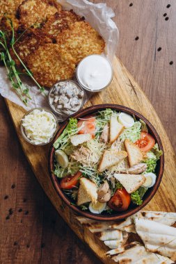 Büyük ve cömertçe nefis yemek masalarıyla kaplı ve üzerinde Ukrayna mutfağının çeşitli yemekleri var: barbekü, kızarmış patates, salata, sos, peynirli pita ekmeği.