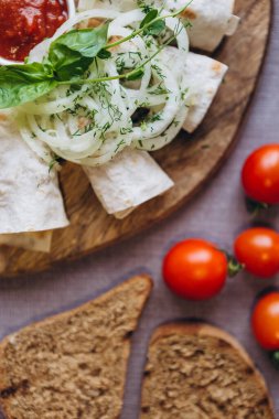 Bir tabak taze salata ve yemek pişirmek için ağız sulandırıcı malzemeler, kırmızı biber, mini domates, ızgara ekmek, mavi soğan.