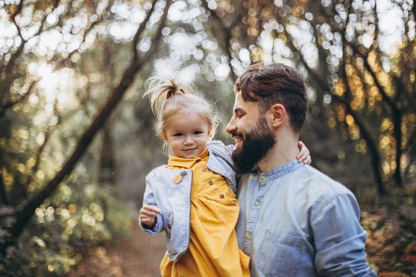 2019ウクライナ ヴィニツァ スタイリッシュなひげを生やした父親は 日没時に自然の中で彼の小さな娘と一緒に歩いています 父親と1人の子供の家族写真 選択的焦点ノイズ効果 — ストック写真