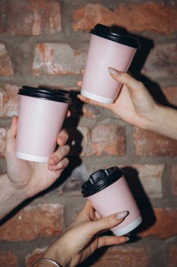 Kadın ellerinde kahve servisi olan üç kağıt bardak, kahve servisi yapılan kafe veya restoran konsepti.