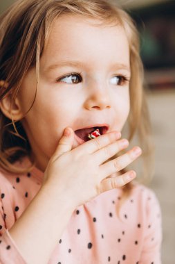 Küçük güzel kız tatlı yiyor.