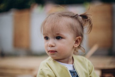 03.06.2018 Vinnitsa, Ukrayna: Evin arka bahçesinde soğuk havada oynayan sevimli küçük bir kızın portresi