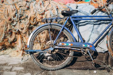 07.07.2018 İstanbul, Türkiye: Eski paslı bisiklet küçük bir balıkçı köyünün iskelesinde büyük bir balık ağlarının yanında duruyor