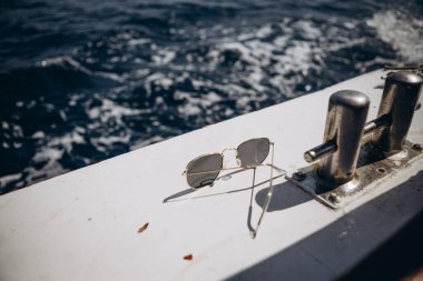 Küçük bir turist teknesinin kayığı açık mavi renkli deniz dalgalarının arka planına karşı doğrudan güneş ışığı altında