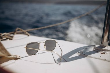 Küçük bir turist teknesinin kayığı açık mavi renkli deniz dalgalarının arka planına karşı doğrudan güneş ışığı altında