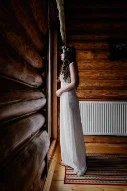 Güzel makyajlı şık bir gelinin portresi, kafasında bir çelenk ve zarif minimalist bir elbise.