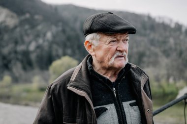 18.04.2019 Verhovyna, Ukrayna: orta yaşlı, bıyıklı fakir bir adamın portresi, dağlardaki küçük bir köyde günlük giysiler içinde yaşıyor.
