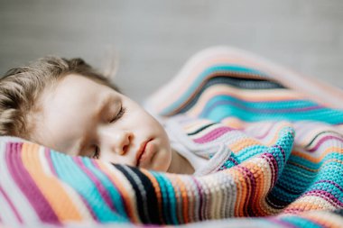 01.06.2019 Vinnytsia, Ukrayna: İki yıllık genç anne ve bebek sarılarak yatıyor, çocuklar için gündüz uykusu kavramı. Annem bebeğini uyuturken uyuyakalmış.