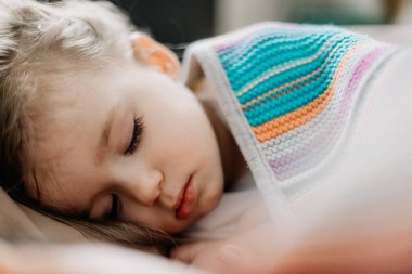 01.06.2019 Vinnytsia, Ukrayna: İki yıllık genç anne ve bebek sarılarak yatıyor, çocuklar için gündüz uykusu kavramı. Annem bebeğini uyuturken uyuyakalmış.