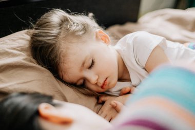 01.06.2019 Vinnytsia, Ukrayna: Güzel, genç bir anne ve tatlı bebeğinin evde uyuduğu yan manzara