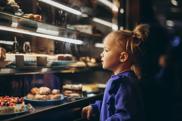 Mooi Meisje Bewonderenswaardig Onderzoekt Een Verlichte Vitrine Met Verschillende Heerlijke — Stockfoto