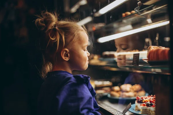 Mooi Meisje Bewonderenswaardig Onderzoekt Een Verlichte Vitrine Met Verschillende Heerlijke — Stockfoto